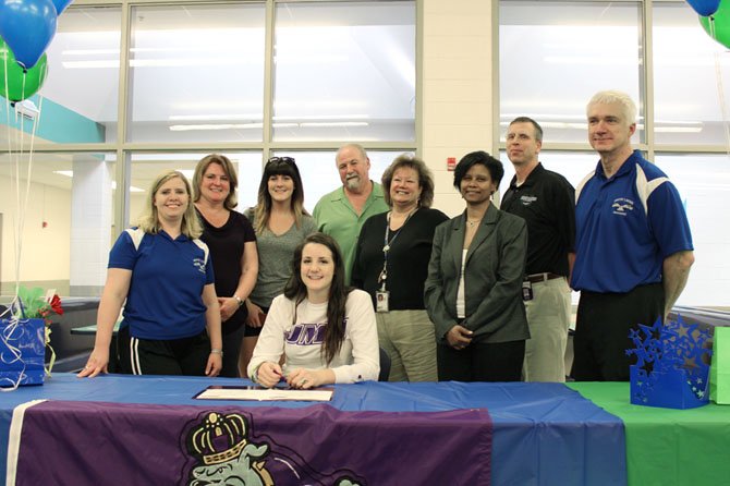 Sarah Delaney (sitting), earlier in May, signed her letter of intent to attend James Madison University next school year. There, she will be a part of the Dukes' women's volleyball team. She celebrated her signing moment with family members and school administrators. South Lakes volleyball head coach Cheri Hostetler is at the far left.  