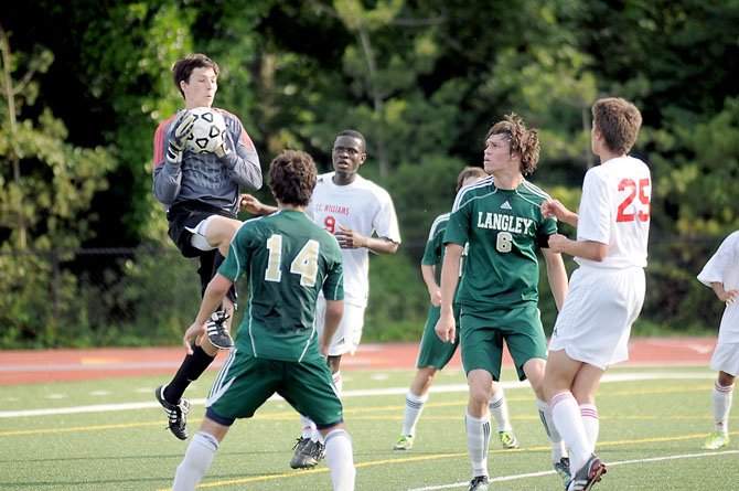 Langley goalkeeper Joshua Lupas catches the ball near teammate Rhys Howard (6) and T.C. Williams’ Alex Mansaray (9) during the Saxons’ 1-0 win in the region quarterfinals on May 24.