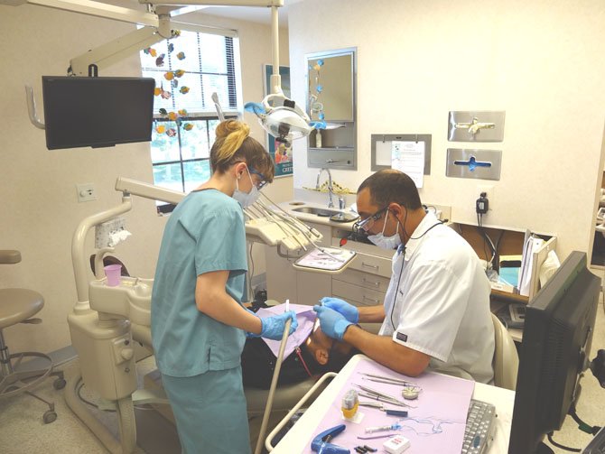 Amber Bentely and Dr. Zeyad Mady treat a UCM program participant at their office’s annual Dental Day.