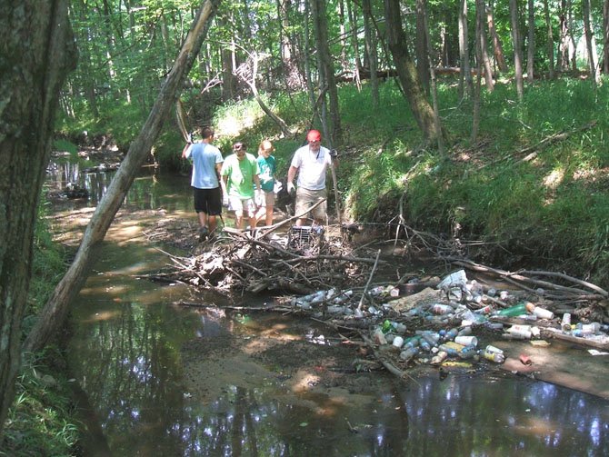 Volunteers remove trash and shopping carts from Little Hunting Creek on May 27.