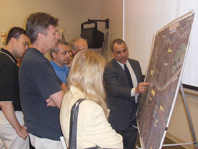 Local residents look at a map showing an aerial view of I-66 and Route 28 in Centreville and Chantilly while VDOT’s Bud Siegel answers their questions.