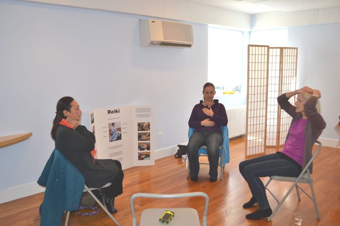 Reiki Masters Christine Mosley, of Springfield; Naning Sugeng, of Potomac, and Marion Werner, of Chevy Chase, perform Reiki self-treatments.