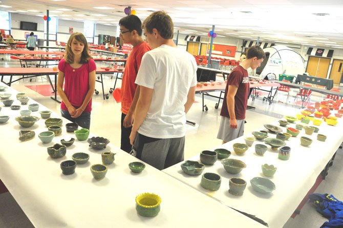 Students at McLean High School examine a selection of bowls made by ceramics students to raise money for Stop Hunger Now, a nonprofit that provides nonperishable meals to the needy around the world.