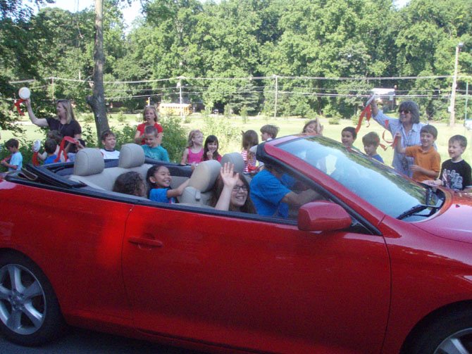 Sarina Bell, Sydney Pham, and Gwyn Murphy wave to their fans and classmates during the parade on May 31.