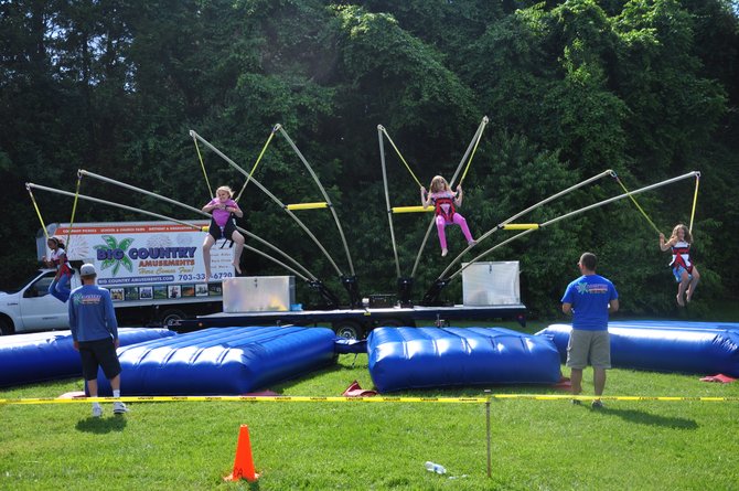 Children jump with the aid of harnesses and bungie cords at the June Fest in Great Falls Sunday, June 3. 