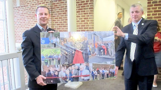 Joseph Harmon, chairman of the City of Fairfax Parks and Recreation Advisory Board and Mike McCarty, director of the city’s Parks and Recreation Department, hold up a collage of photos for retiring Mayor Robert F. Lederer. 