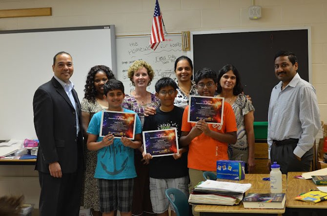 Front row, from left, are Team: Epic Einsteins — Saiteja Bevara, Ajith Kanuri and Dheeraj Bandrau — joined by, back row, from left, an Ecybermission Ambassador, GBW Vice Principal Lauryn Campbell, GBW Principal Lori Cleveland, Team Advisor Padmaja Bevara, parent Vasavi Bandaru and parent Ravi Kanuri.