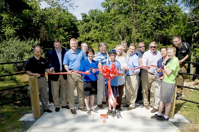 From left: Park Authority Board Member Tony Vellucci, Braddock District representative; Patrick Gloyd, executive director of the Burke Centre Conservancy; Braddock District Supervisor John Cook; Kevin Morse, Burke Centre resident; Sharon Bulova, Chairman of the Fairfax County Board of Supervisors; Joe Osborne, Burke Centre resident; Kala Quintana, at-large member, Park Authority Board; Kemp Skudin, trails enthusiast; Chris Wells, pedestrian program manager, FCDOT; Steven Pryun with the Avon Corporation; Mark Avon, president of the Avon Corporation; Marc Flaster, vice president Burke Centre Board of Trustees; and Project Manager Tom McFarland. Others, not identified in the photo, took part in the inaugural bicycle ride along the trail.

