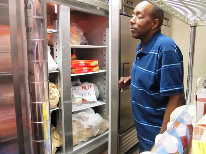 Wilber Shaw, with the Embry Rucker Community Shelter in Reston, checks the pantry’s freezer for food on Saturday, July 7. 

