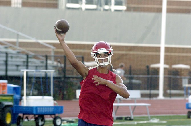 T.C. Williams quarterback Alec Grosser throws a pass during a "green" practice on July 10 at T.C. Williams High School.