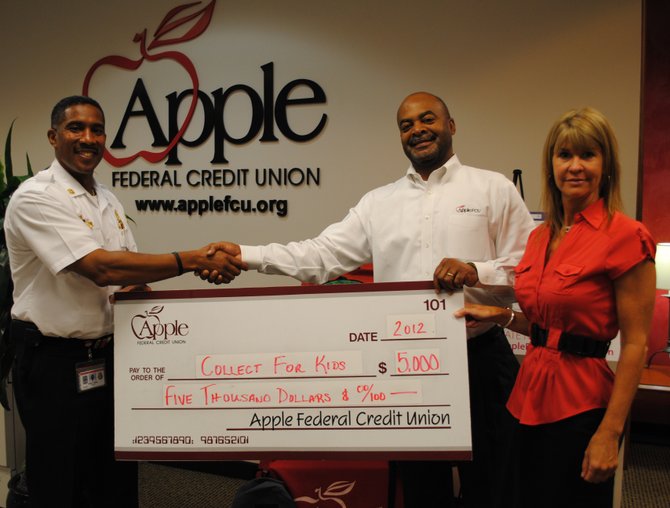 Apple Federal Credit Union pledges to match up to $5,000 in "Collect for Kids" contributions to buy school supplies for low-income Fairfax County children. Shown here left to right are Captain II Willie F. Bailey, aide to the assistant chief of personnel services, Fairfax County Fire and Rescue Department, and from Apple, Robert Sowell, vice president of community relations, and Cynthia McAree, vice president of marketing.