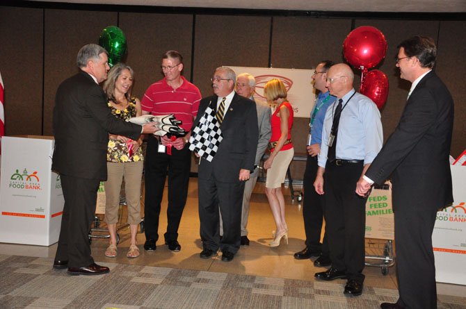 Members of the Office of Personnel Management, Rep. Frank Wolf (R-10) and Rep. Gerry Connolly (D-10) kick off the Feds Feed Families event, which supports local food banks, Monday, July 16. 