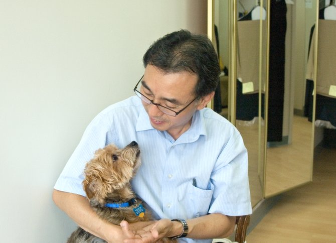 Deuk Kim and Mash sit in their shop in Great Falls Village, where Mash has been accompanying his owners for twelve years.