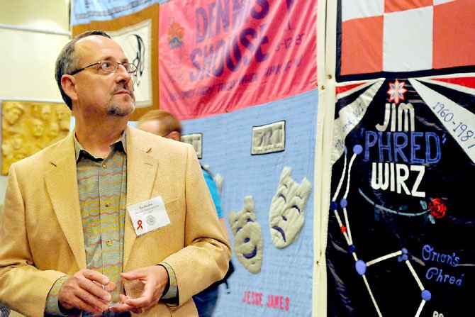 Tom Suydam of the Alexandria Commission on HIV/AIDS ponders the life and death represented in the panels of the special exhibit on Friday evening.