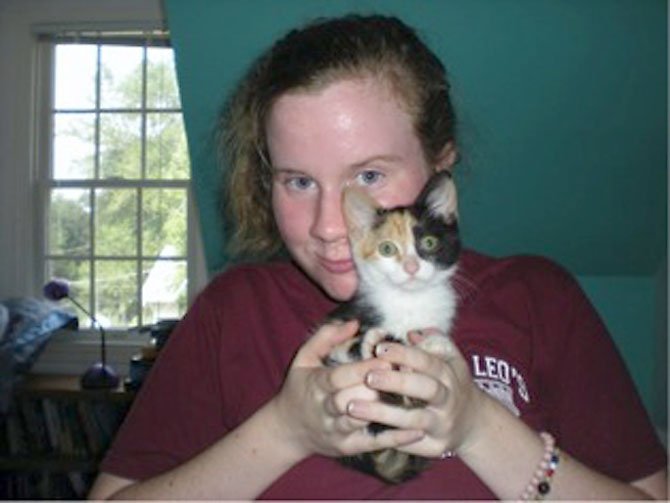 Becky Conway plays with her only cat, Laser.