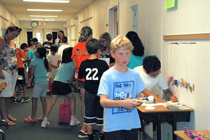 Teachers Kathleen Stakem and Jeannette O’Malley talk with students during the market, held on the last day of the week long economics camp. 