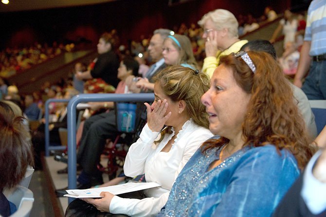 Khatira Alvarez (left), of Springfield, and Laura Simon-Salzer, of McLean, are both visibly moved moments after they have taken the Oath of Allegiance and become naturalized American citizens at a ceremony on July 10, held in the Hayfield Secondary School auditorium.