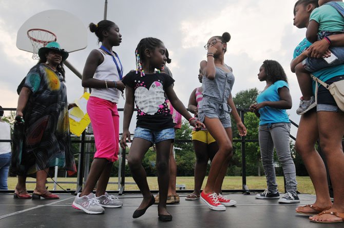 Girls participating in the summer program at the community center gather together for a group dance from First Lady Michele Obama’s “Move Your Body” initiative.