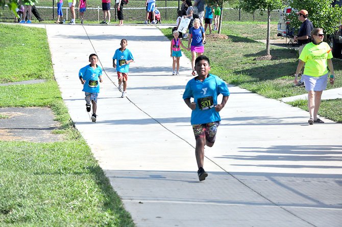 Runners prepare to enter the South Lakes High School track, the final leg of the Reston Youth Triathlon, Sunday, Aug. 12. 