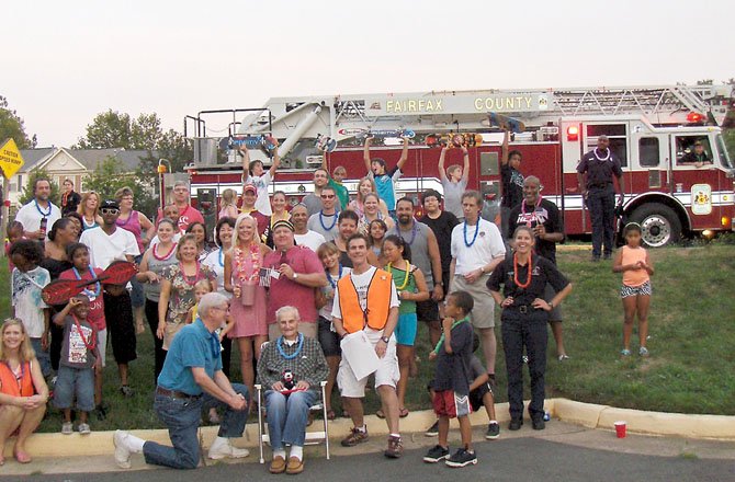 A group shot of residents and Station 38 firefighters at Belcher Farm and Beaumeadow Court. Sheree Glaze and Clint Crawford (in center, in cap and holding flag) organized this block’s party with Bill Worthington.