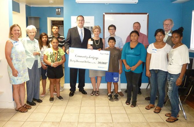 Community Lodgings Executive Director Bonnie Baxley, center, receives a check for $30,000 from store manager William Hunsucker on behalf of the Walmart Foundation. The funds will be used to support after school programs for homeless and low-income middle and high school students. Along with program participants, Baxley is joined by board members Marty DeVine, Helen Lewis, Barry Roman and George Tuttle.