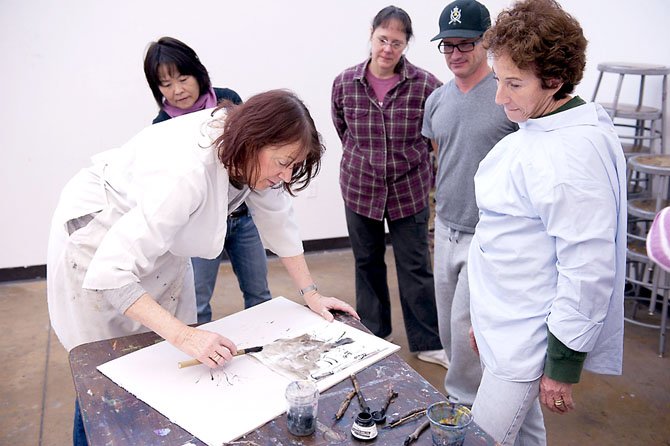 Students at a McLean Community Center art class work on one of their pieces. 