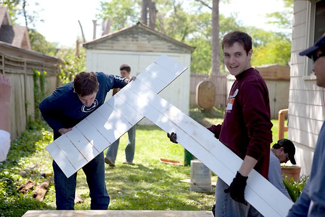 Rebuilding Together volunteers make repairs to a resident’s front porch.