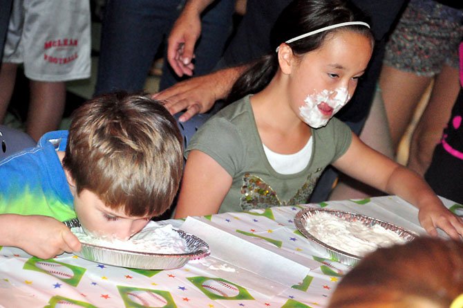 From left, Eli Rutter, 7, and Sofia Belvedere, 10, race against each other in a pie-eating contest at the Old Firehouse Teen Center Saturday, Aug. 25.