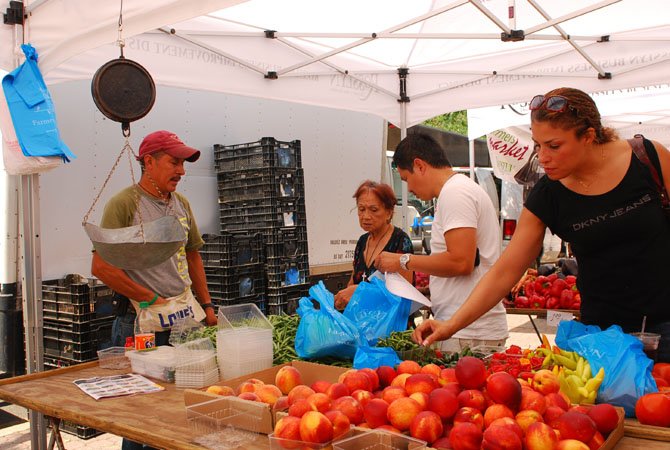 Visitors shop at the Valdez brothers’ produce stand at the Rosslyn Farmers Market.