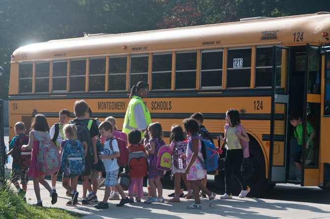 School buses unload students on the first day back to school.