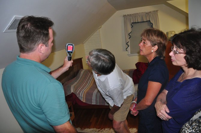 Guests at a McLean residence examine a thermal camera reading from Marty Valentine of Home Performance Solutions Wednesday, Aug. 29. Valentine performed an energy audit as part of a pilot program by Energy Action Fairfax. 