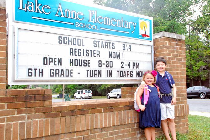 Kindergartener Caroline Kohn poses in front of Lake Anne Elementary with her brother, third grader Will Kohn.