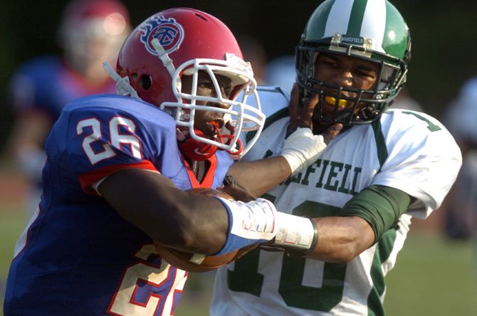 T.C. Williams running back Dealo Robertson stiff-arms Wakefield’s Khory Moore during the teams’ Aug. 30 contest at T.C. Williams High School.