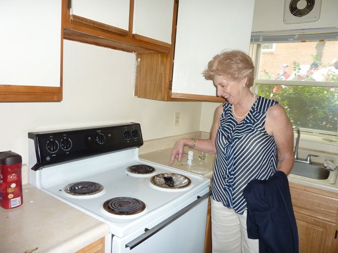 Executive Director Bonnie Baxley points to the dilapidated stove in an apartment slated for renovation for Community Lodgings.