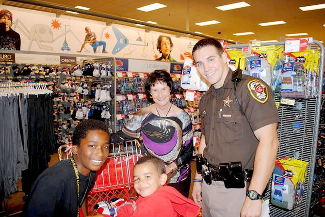 Fairfax County Board of Supervisors Chairman Sharon Bulova and Fairfax County Police Officer Nick Andariese with Justin (left) and Dylan (right) during the 19th annual Shop with a Sheriff event at the Burke Target. 