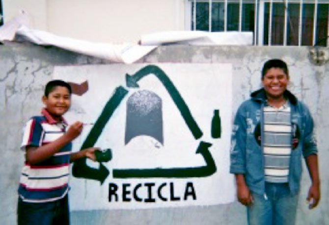 Justin Seara’s host brothers (from left) Cristian, 14, and Ivan, 15, standing next to a freshly painted recycling mural.