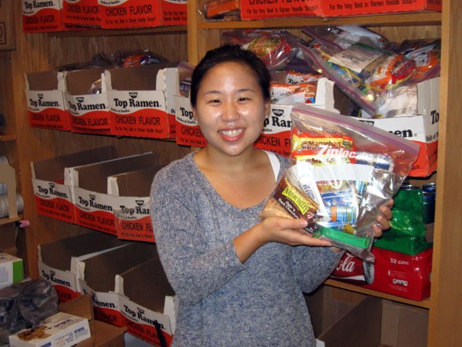 Centreville Elementary counselor Esther Kang holds up a sample of the food bags that children will receive.