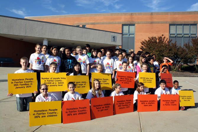 Students hold signs telling facts about homelessness before a previous, WFCM Help the Homeless walk. 