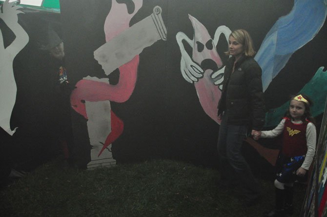 From left, Julie and Tyler Collins, 6, make their way through the Haunted House on the Great Falls Village Green. This year’s haunted house will be hosted by the Great Falls Friends and Neighbors. 