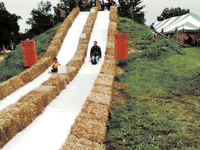 Richard Graves and son Evan slide down one of the carpet slides at the Burke Nursery Pumpkin Playground last year.
