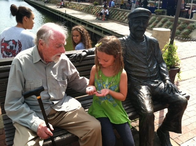 Bob Simon asks Sarah Culver, age 7, about the bowl and magnet she made at the Reston Multicultural festival. 