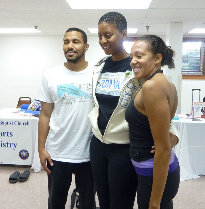 Nigel Greaves, Faith Bynoe and Daemon Jones pose for a photo following a yoga demonstration at the Alfred Street Baptist Church Community Health Fair.
