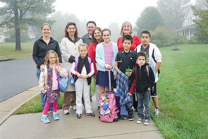 First gathering point: Dranesville Elementary students Mia, Lexi, Rose, Willy, Michael and Jeffrey (up front, right) are ready to take part in International Walk to School Day. They were accompanied by a few parents, and by school Principal Kathryn Manoatl, prepared for the weather with her raincoat, and dressed in red school, Registrar Chris Toye.