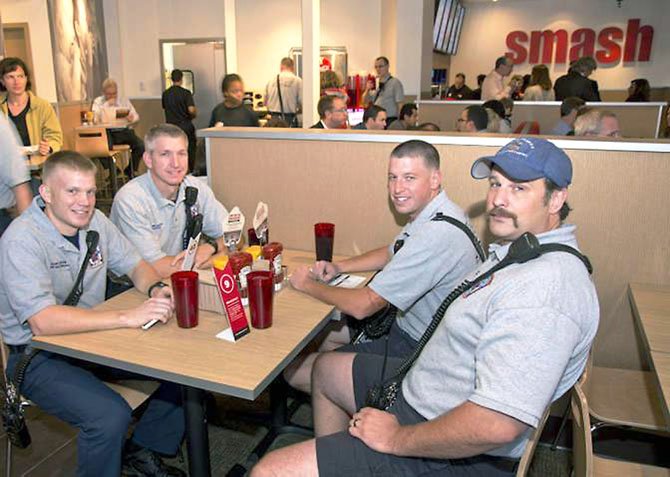 City of Fairfax Fire Department Captain Jeremy Speakes, right, tries a Smashburger with other fire officials. 