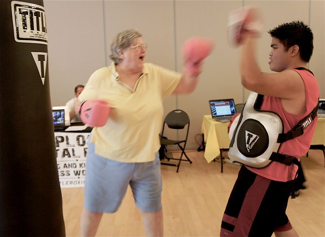 Karyl Moesel of Vienna looks like a pro as she spars with trainer AJ Smiley from Title Boxing Club in the City of Fairfax. Moesel says she was looking for something a little more active and interesting than the traditional offerings for the Non-Youth groups. 

