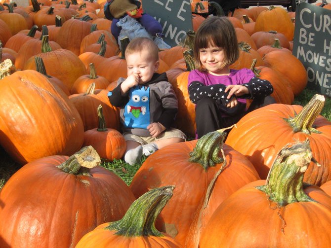 Carter Moorman and Claire Trombley sit among the pumpkins.
