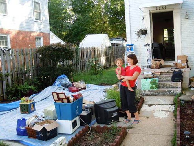 A Huntington mom holds her daughter as she surveys the damage to her home that was flooded during Tropical Storm Lee.
