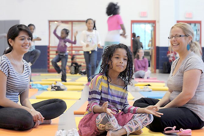 Imena Samson strikes a lotus position in the yoga warm-up. Imena came with her mom, Shanna, and Fernanda Pinedo, an exchange student from Mexico studying at T.C. Williams High School.
