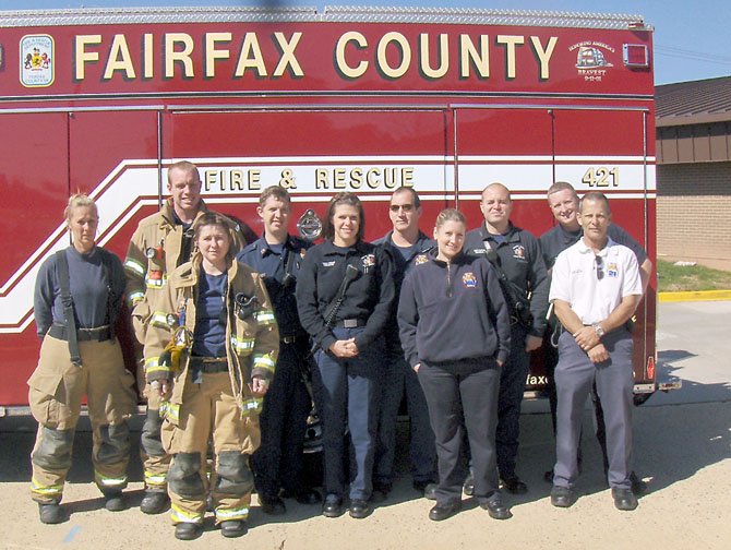 Some of Station 21’s B Shift firefighters and EMTs stand beside one of their engines, after returning from a call. (Back row, from left) are Annita Reynolds, Ryland Chapman, Adam Lieb, Mike Lattanzio, Rudy Iturrino and George Coyne. (Front row, from left) are Svetlana Feofanova, Marcy Kinkaid, Kelley Wine and Station Chief Mark Servello.