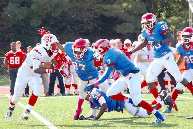 T.C. Williams defenders Kyreem Walton (27) and Rashawn Jackson (7) close in on an Annandale ball carrier during the Titans’ 52-7 homecoming victory on Oct. 20.